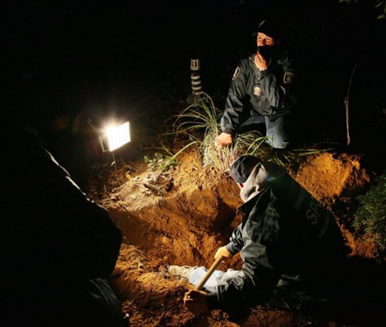 Officers from the Society for the Prevention of Cruelty to Animals unearth animal remains on Nov. 7, 2009 in the backyard of Sharon McDonough's Selden, N.Y., home in Suffolk County, Long Island, where 42 dead animals were found buried in her yard.